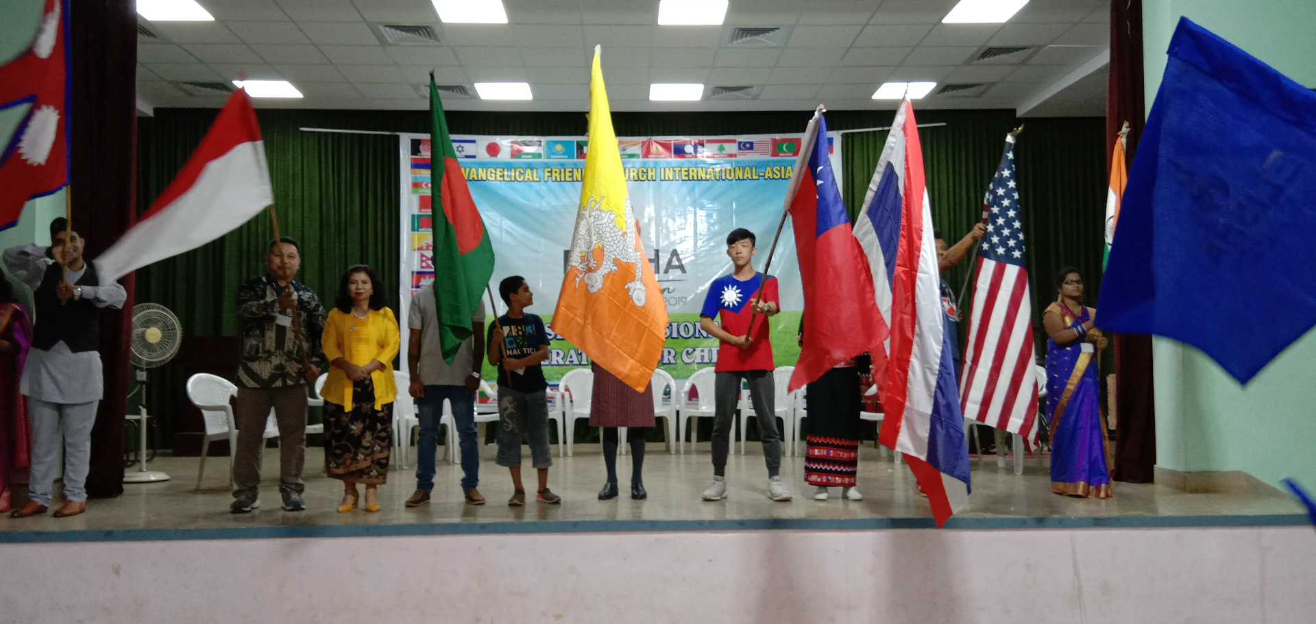 Delegates carrying the flags of Asian nations on stage