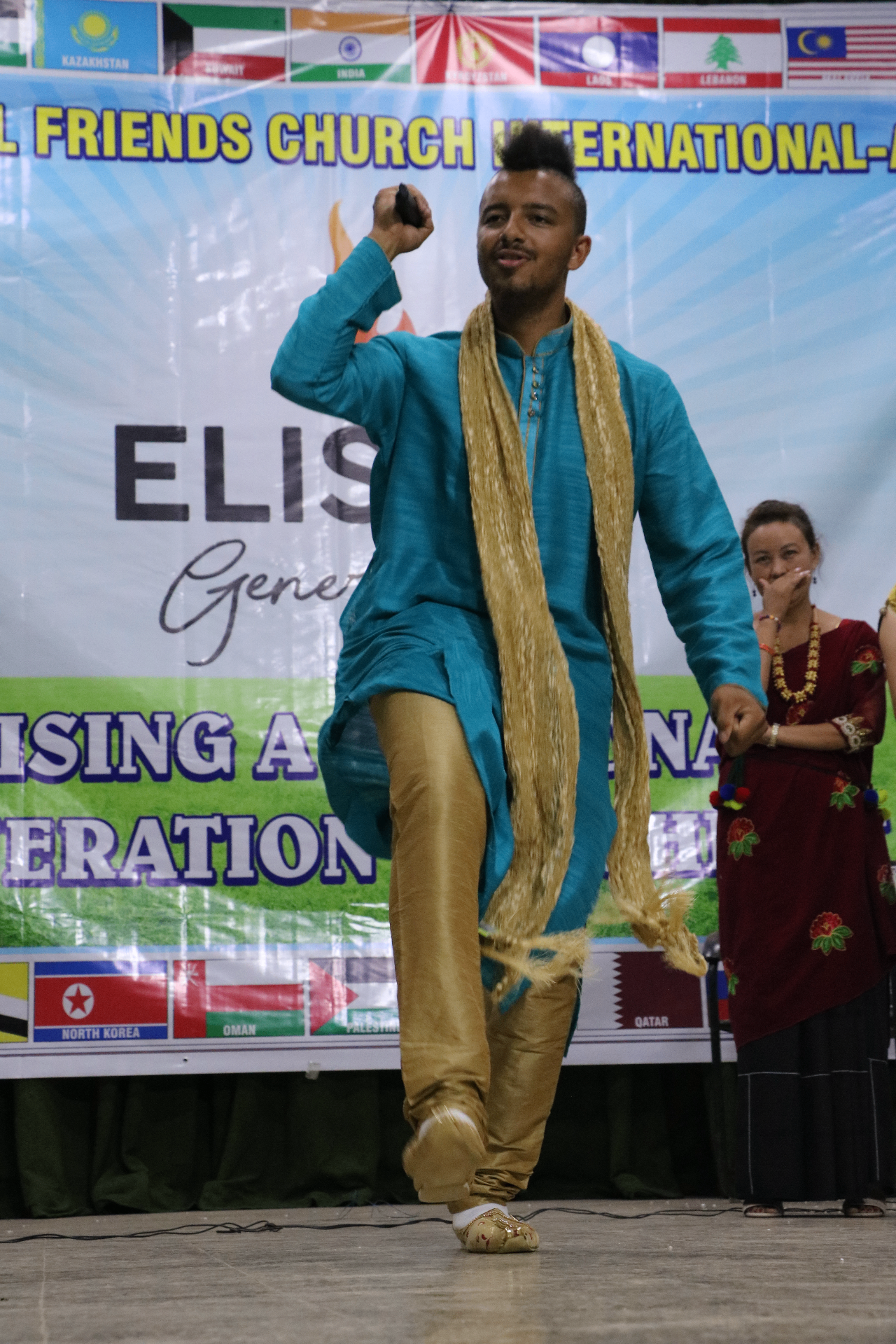 Delegate performing a cultural dance on stage